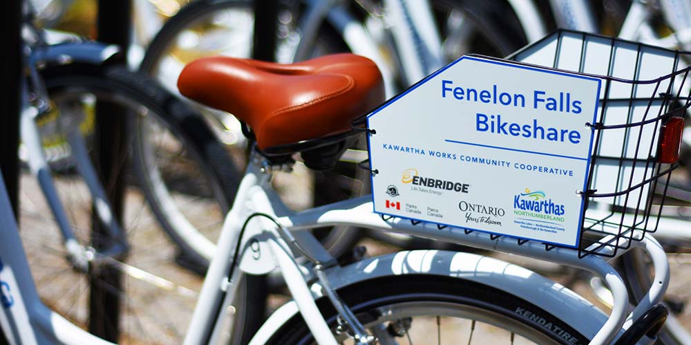 Image of a bike saddle and basket reading "Fenelon Falls Bikeshare"